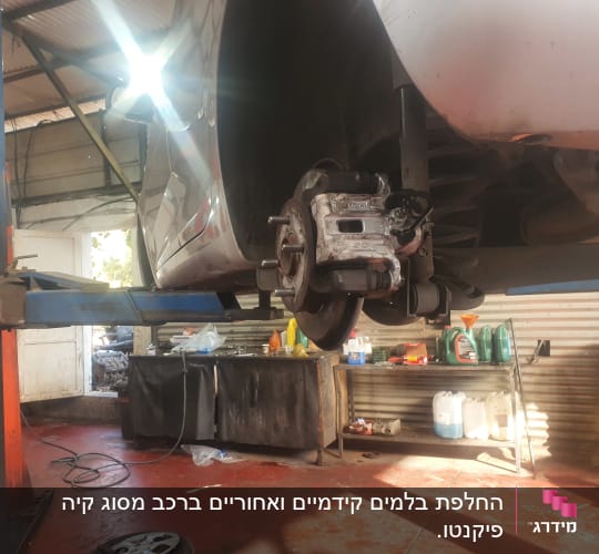 רכב מורם במוסך עם בלם חשוף על ליפט